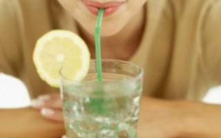 Девушка пьет воду с лимоном