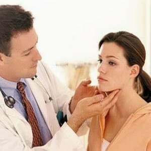 Врач проверяет щитовидку у женщины