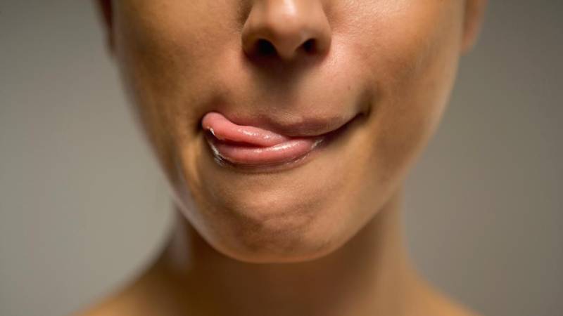 Женщина облизывает губы