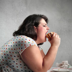 Толстая женщина ест