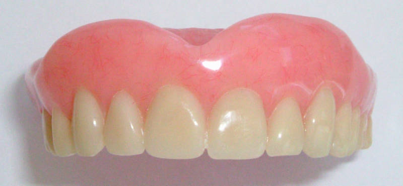 Зубной протез на белом фоне