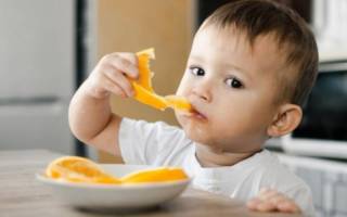 Ребенок ест апельсин