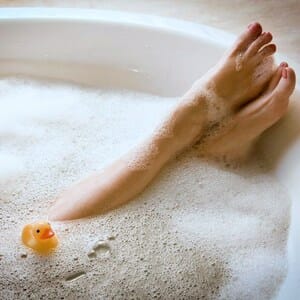 Ноги в ванной и резиновая уточка