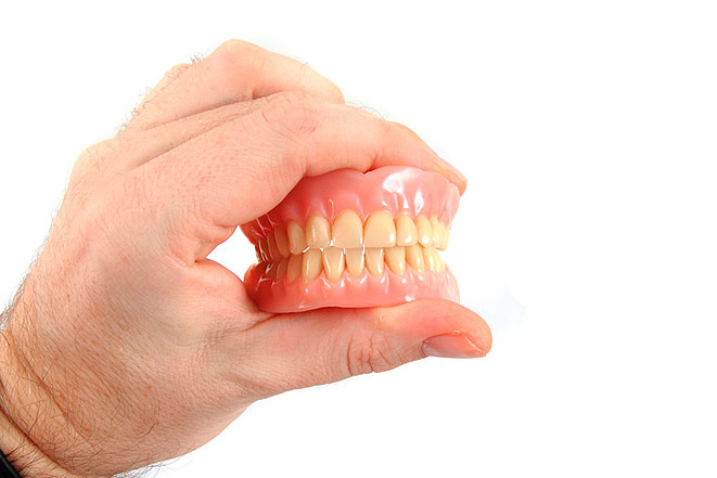 Зубные протезы в руках